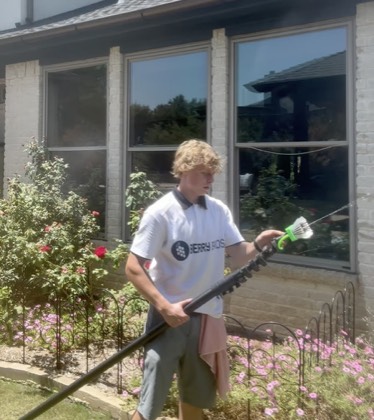 Berry Bros technician cleaning exterior windows with a water-fed pole