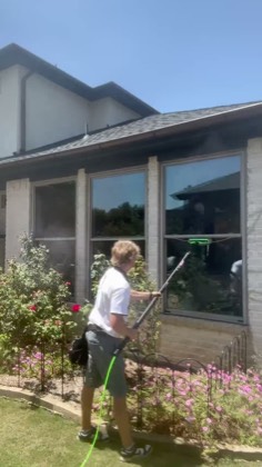 Technician cleaning windows on a newer home