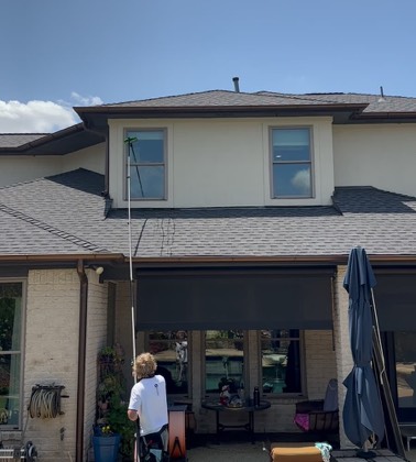 Water-fed pole reaching a two-story roofline